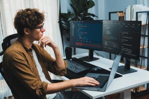 Programador concentrado desenvolvendo códigos em múltiplas telas, representando o impacto de um curso de informática avançado. A qualificação abre portas para carreiras promissoras na área de tecnologia. 