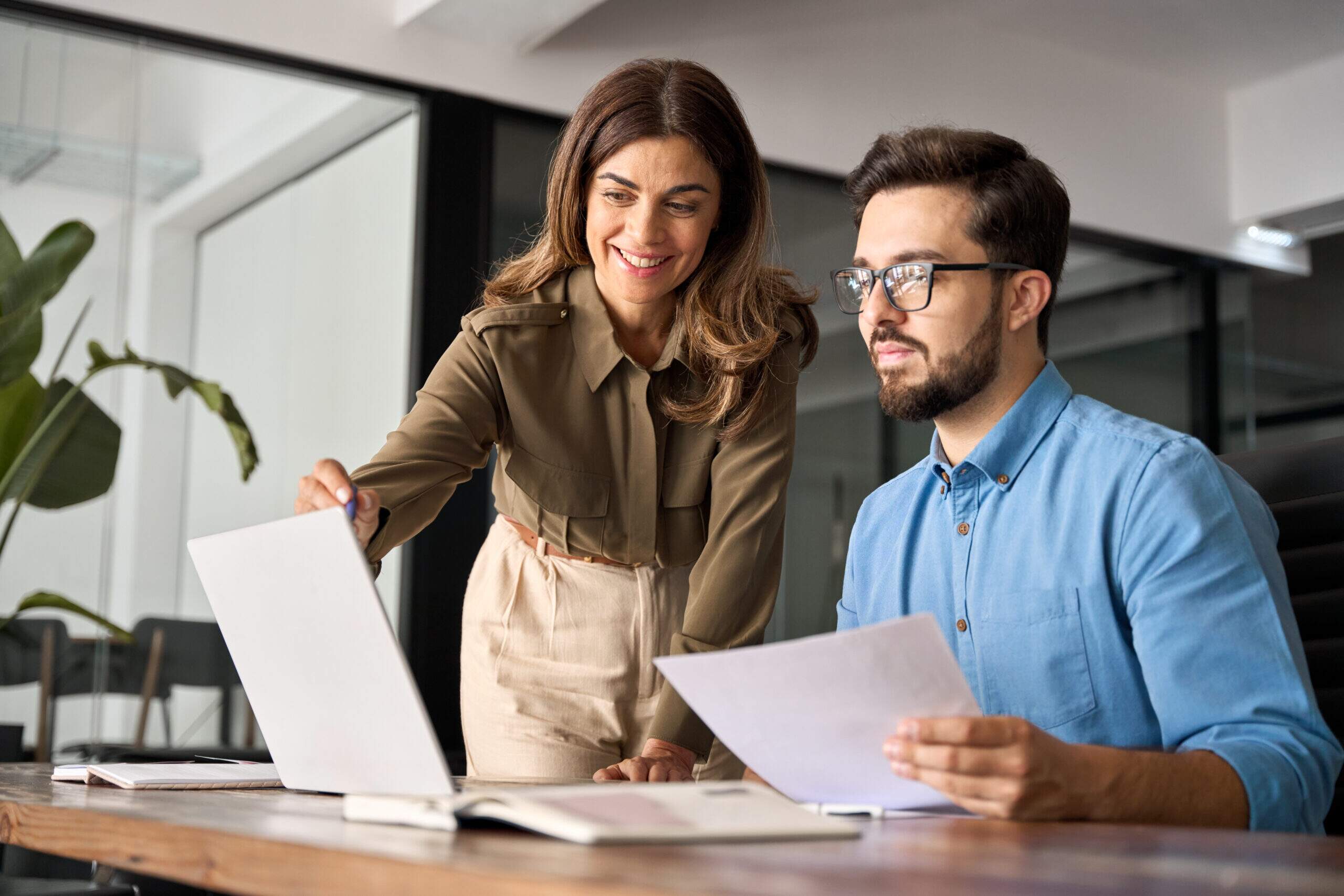 Profissional sorrindo durante conversa com colegas em ambiente de trabalho colaborativo — competências socioemocionais