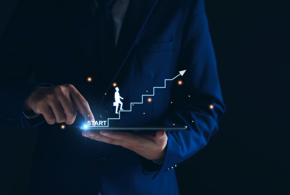 Representação digital de uma pessoa subindo escadas projetadas de um tablet, simbolizando o início da jornada profissional rumo às profissões do futuro.