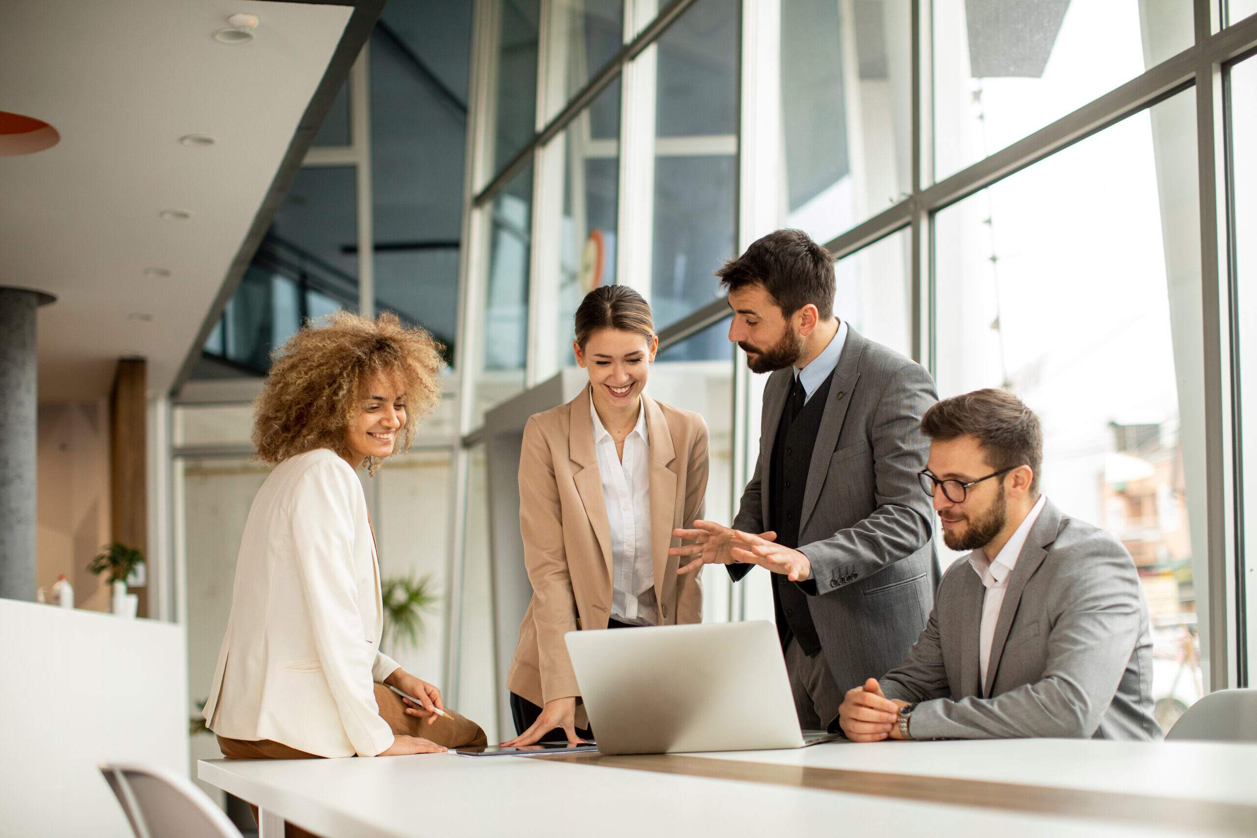 Profissionais reunidos em escritório durante reunião colaborativa, demonstrando habilidades para trabalhar em equipe e comunicação no ambiente corporativo.