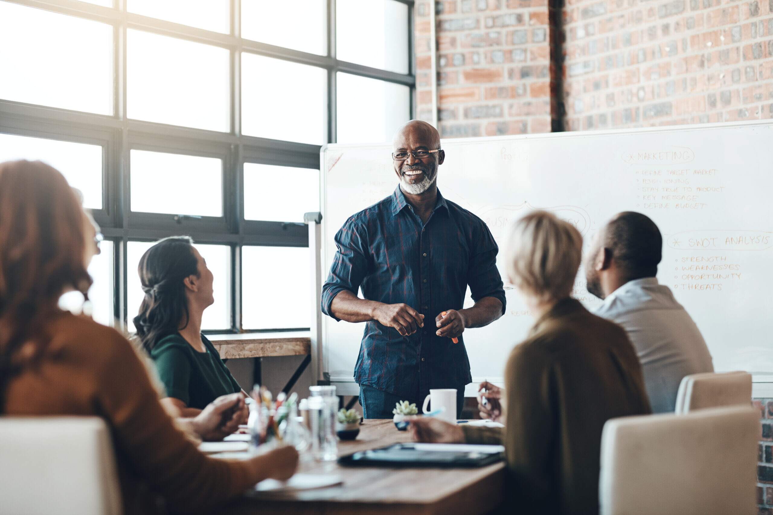 como desenvolver liderança no trabalho com equipe em reunião e gestor conduzindo pessoas