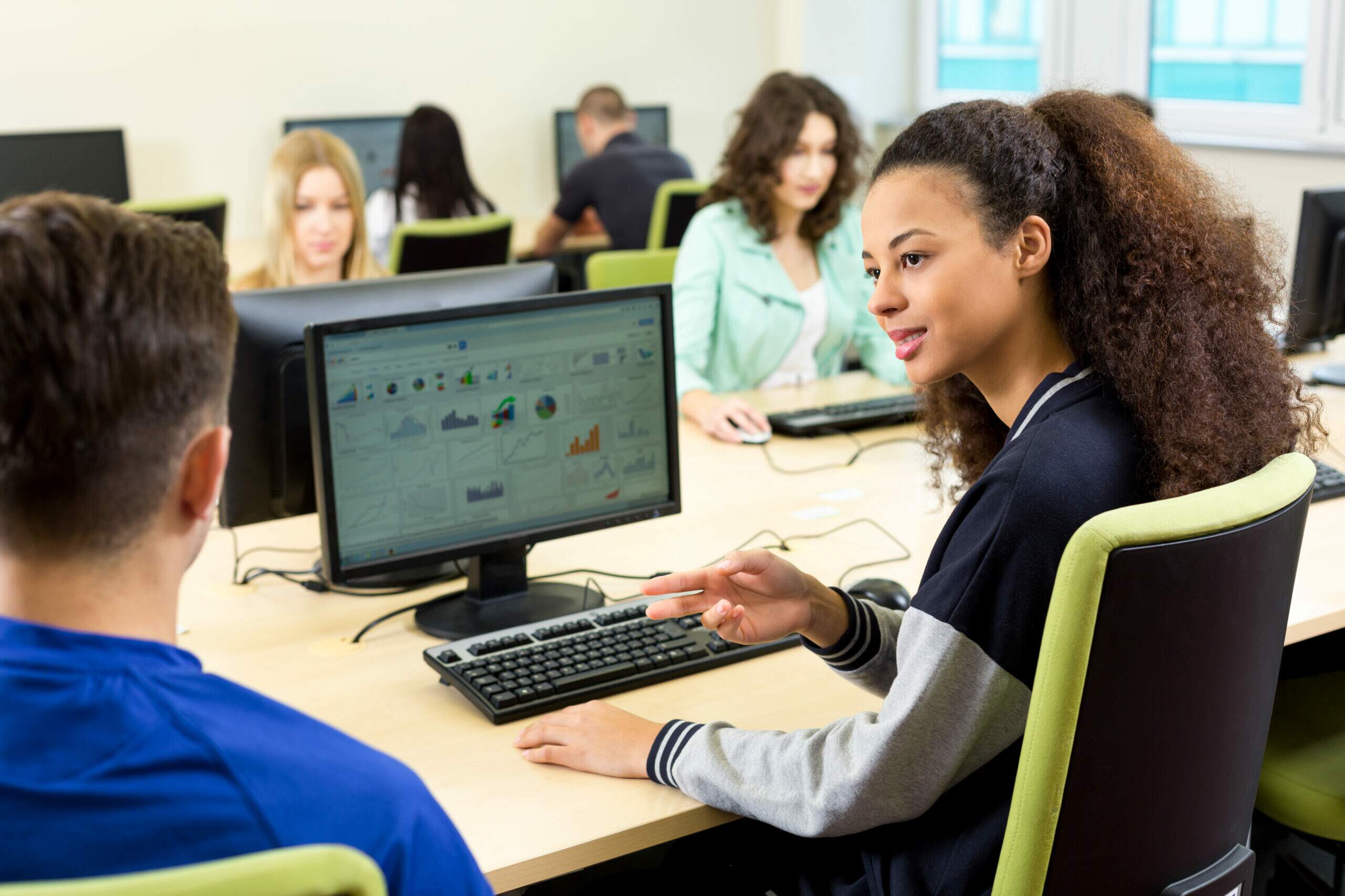 Alunos participando de um curso de informática com atividades práticas em laboratório e uso de ferramentas digitais para o mercado de trabalho.