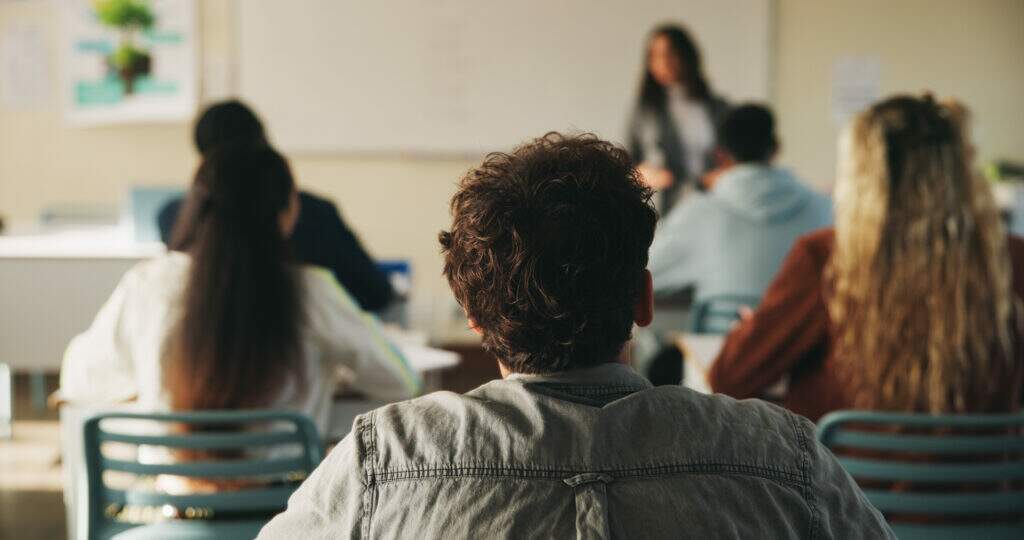 Jovem participando de aula prática de curso profissionalizante, desenvolvendo habilidades técnicas para o mercado de trabalho.