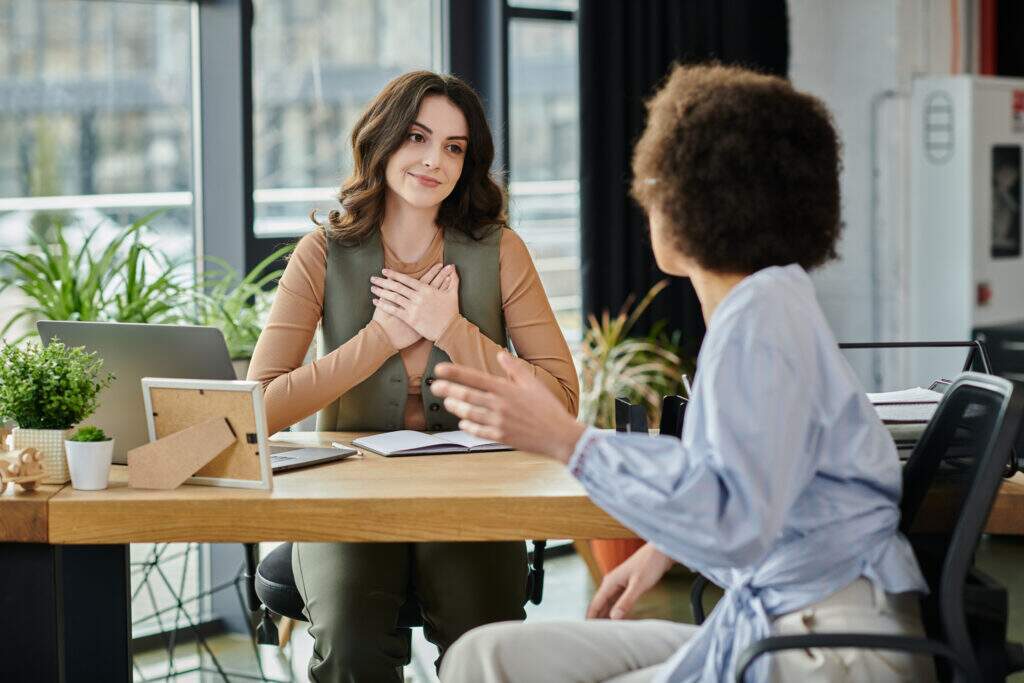 Empatia no trabalho durante conversa entre colegas em ambiente corporativo, demonstrando escuta ativa, compreensão e comunicação respeitosa.